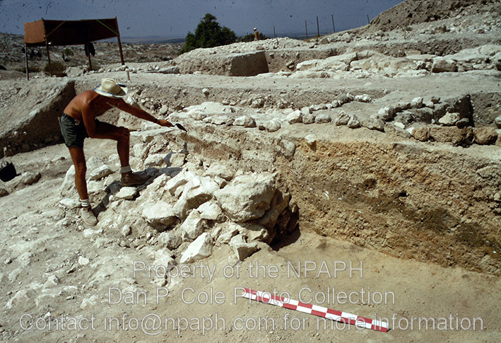 Fld IV; Trowel is on mud-brick over stone course of MB city wall; to right is burned collapsed mud-brick from upper courses. (1973, ID: cColepGezer080, Source: slide, Repository: NPAPH-project, Creator(s): Dan P. Cole)