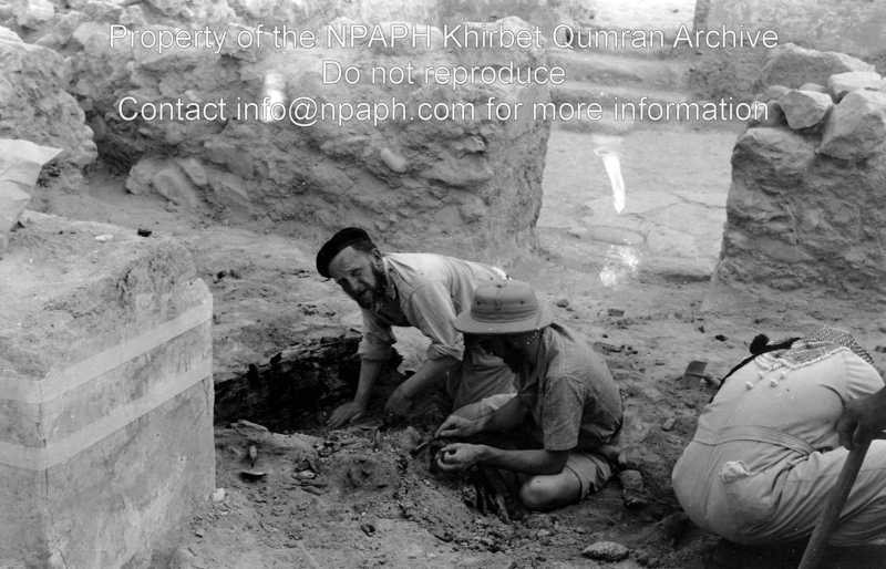 View from L.86 to the north. Two students of the Ecole Biblique are laying bare wooden remains in front of a block in L.86-87, 89, known as the ‘pantry’ (21 March 1954; ID: cBoerpQumran12.11; Source: photo; Depository: NPAPH; Creator(s): Leo Boer)