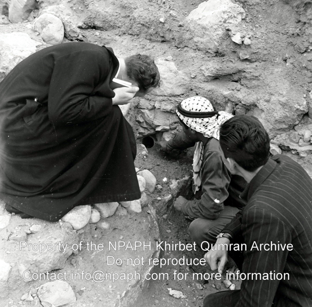 A Bedouin is showing Leo Boer (left) and Jan Glissenaar (right) the mouth of a jar buried in the rubble. Exact location is unknown (31 Dec 1953; ID: cPennartspQumran10; Source: photo; Depository: NPAPH; Creator(s): Peter Pennarts)